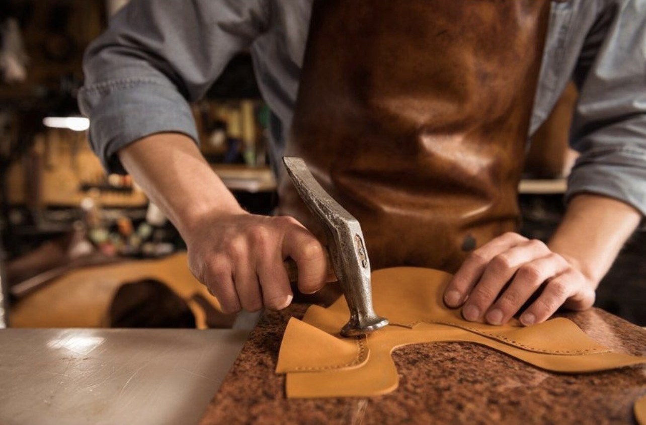 An artisan hand-tooling leather
